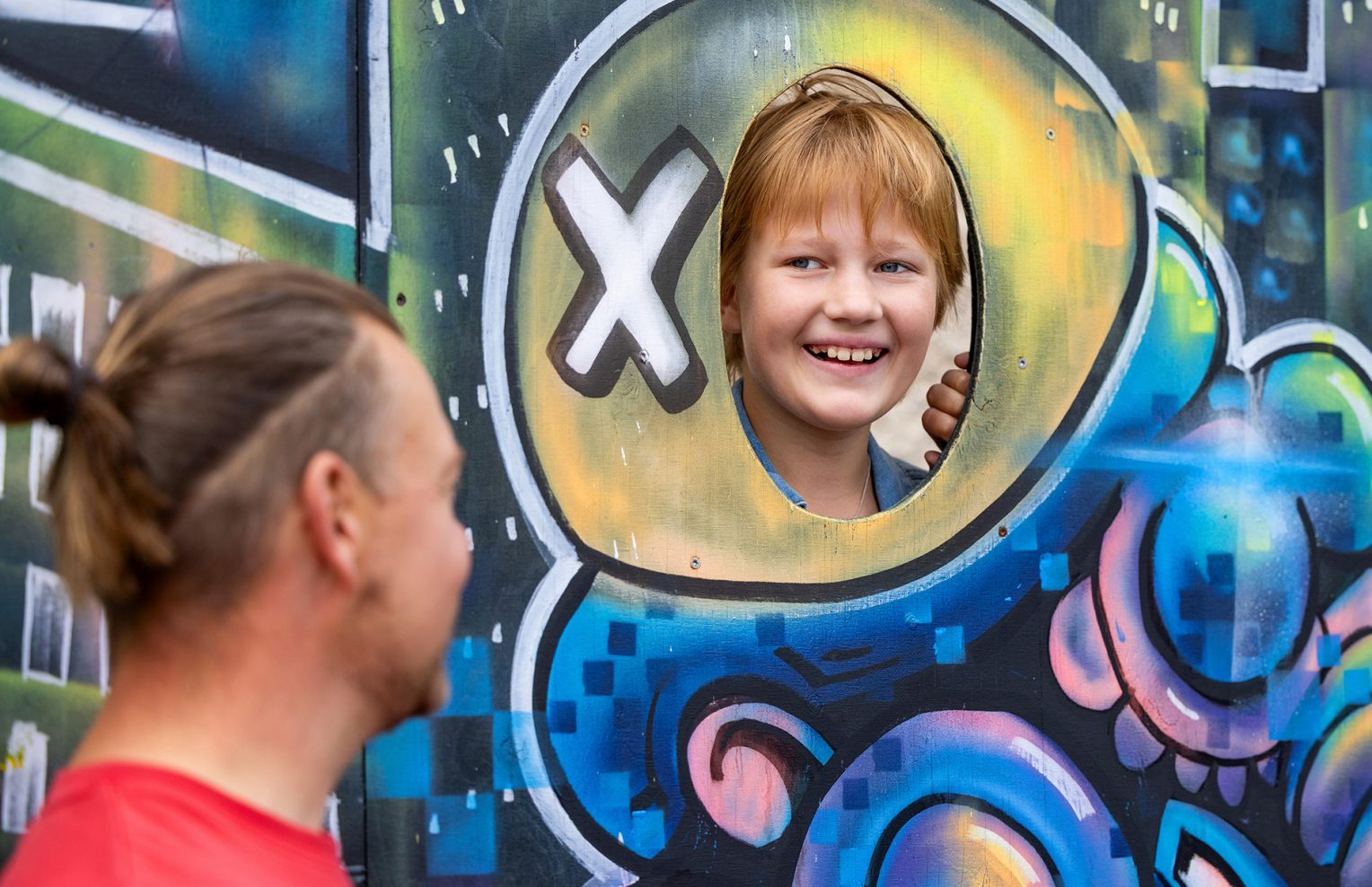 Mies ja poika Vihdin Kultsan värikkäällä kuvausseinällä