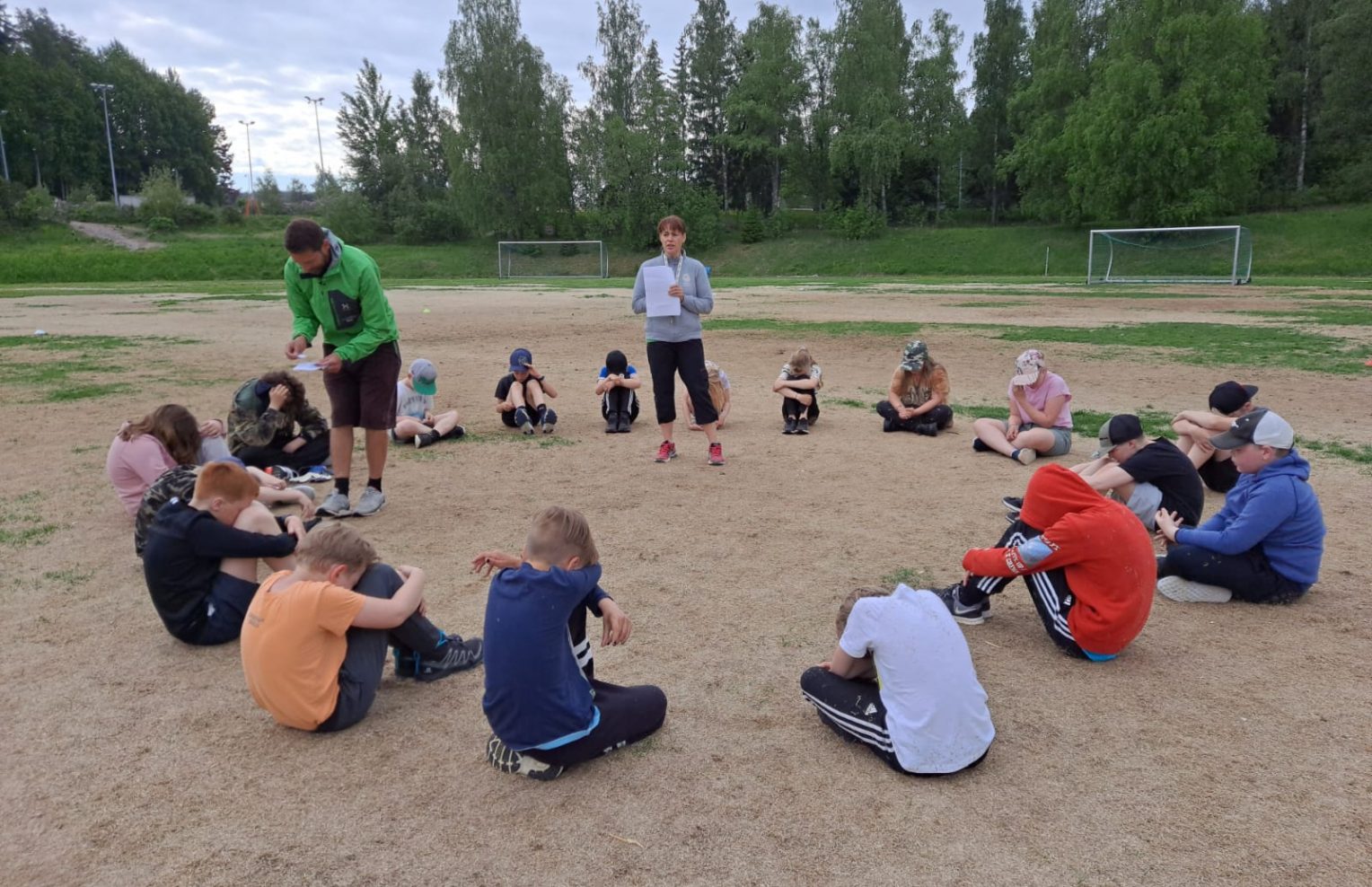 Lapset istuvat piirissä ulkona