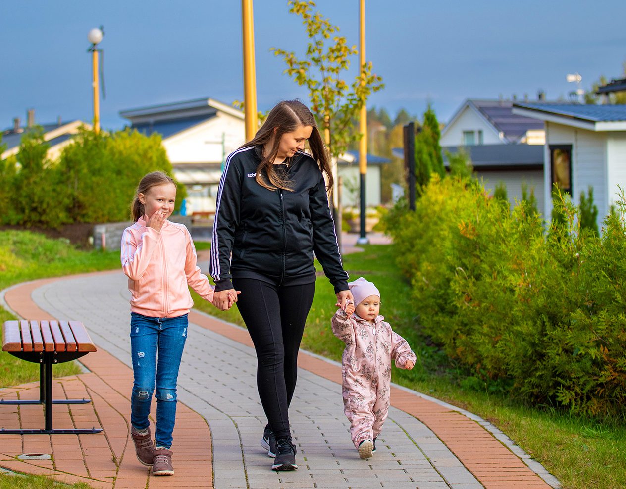 Äiti ja kaksi lasta kävelyllä