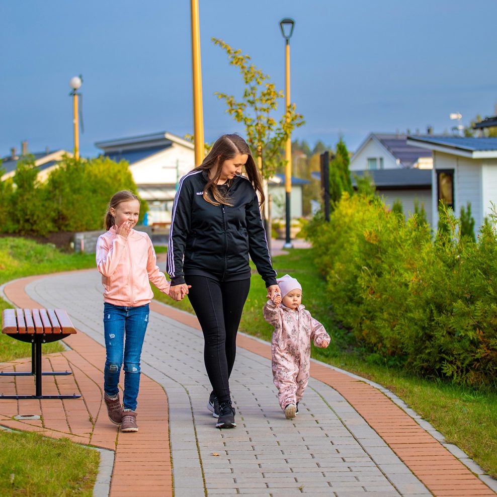Äiti ja kaksi lasta kävelyllä