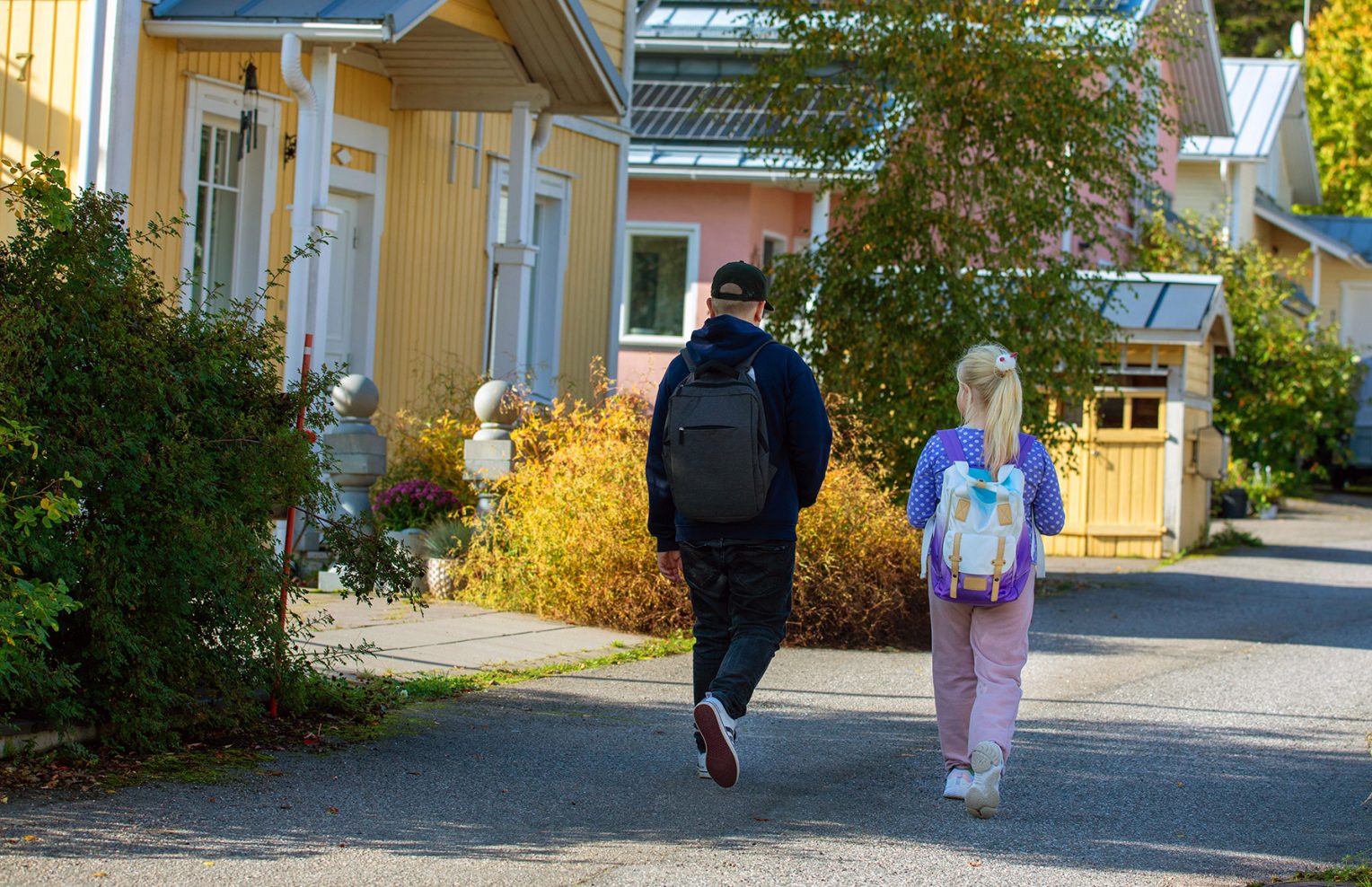 Kaksi lasta koulureput selässä