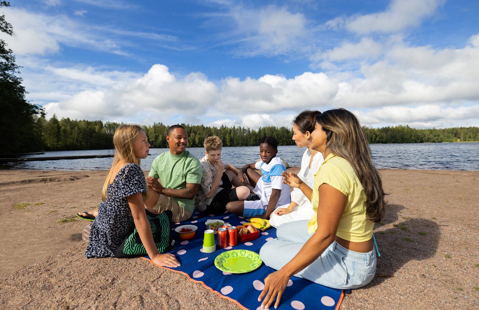 Henkilöitä piknikillä uimarannalla